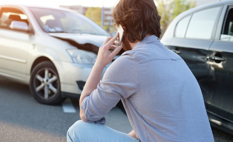 Photo of man on the phone after a car accident 