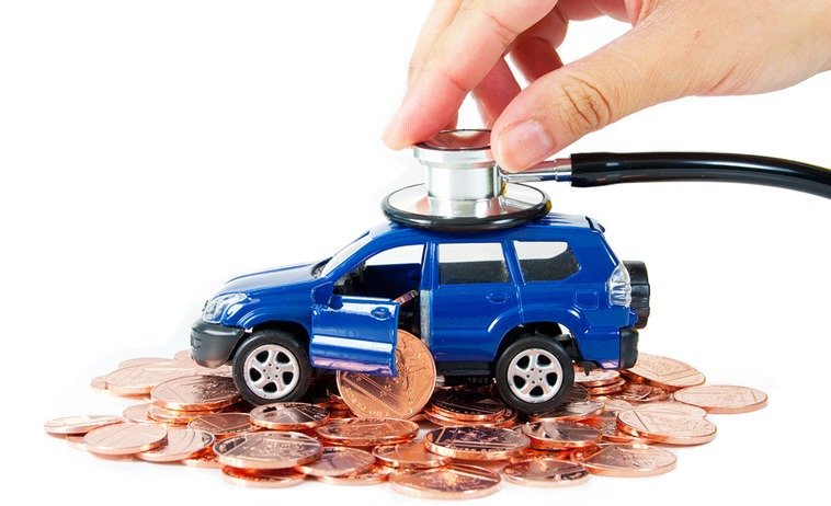 Photo of a toy car driving on a road of coins as a stethoscope examines it