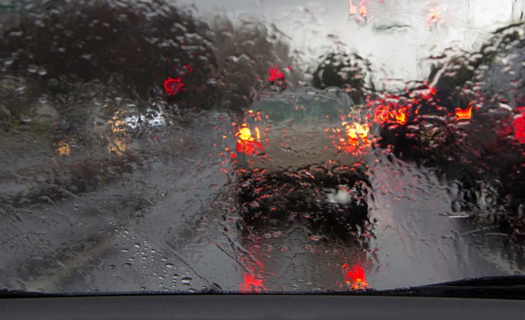 Photo of a car driving in the rain
