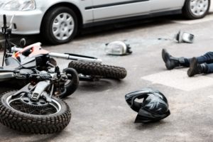 person lying on the road after a motorcycle accident